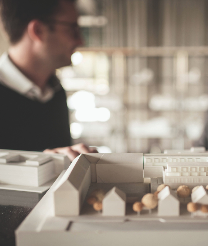 Eine Person, die vor einem Architekturmodell steht
